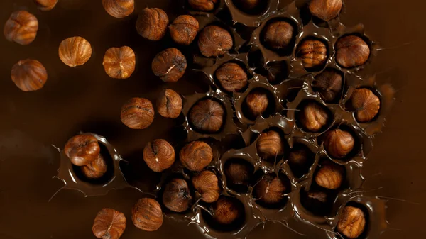 Super Slow Motion Falling Hazelnuts Dark Hot Melted Chocolate Close — 图库照片