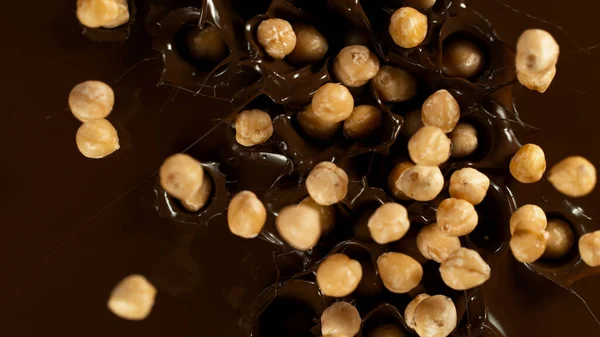 Falling Blanched Hazelnuts Dark Hot Melted Chocolate Close Top Shot — Stockfoto