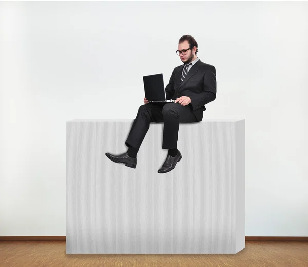 Biznesmen siedzi na ścianie — Zdjęcie stockowe