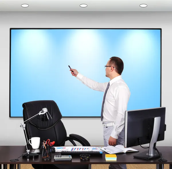 Hombre de negocios apuntando al panel de plasma — Foto de Stock