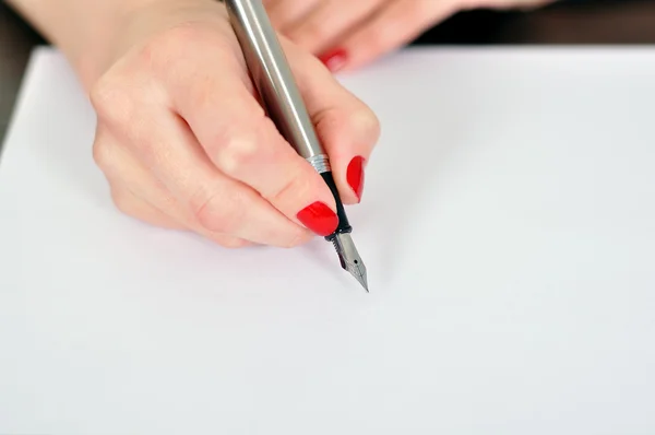 Рука с перьевой ручкой — стоковое фото