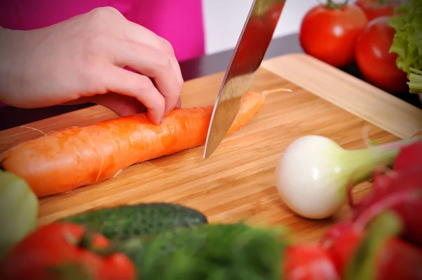 Chef cuts fresh carrot — Stock Photo, Image