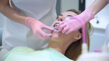 Dişçi, hastanın ağzına ağız halkası takıyor. Sağlık ve Stomatoloji Konsepti