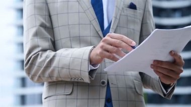 Takım elbiseli tüccar şehirde iş raporlarıyla çalışıyor ve plan yapıyor. Finans ve Ticaret Konsepti.