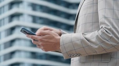 Takım elbiseli tüccar elinde akıllı telefon tutuyor. İş ve Teknoloji Konsepti. Yavaş Hareket Etkisi. Kapat.