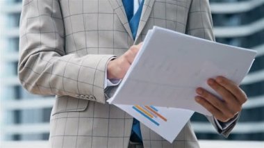 Takım Elbiseli Finansal Danışman. Şehirdeki iş raporlarıyla birlikte çalışma ve planlama. Finans ve Ticaret Konsepti. Yavaş Hareket Etkisi. Kapat.