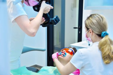 Diş beyazlatma işleminden önce dişlerin fotoğrafını çeken bir diş hekimi. Diş ve Diş beyazlatma Konsepti.