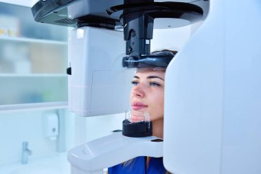 Genç bir kadın hasta, dişçi bilgisayarlı tomografi yapıyor. Diş ve sağlık hizmetleri konsepti. Kapat.