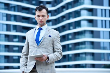 İş adamı raporla dijital tablet bilgisayar ekranına bakıyor. İş ve bilgi teknolojisi kavramı. Kapat.