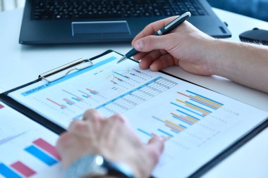 Muhasebeci adam kalem analizi ve hisse senedi verilerini inceliyor. İş ve evrak kavramı.