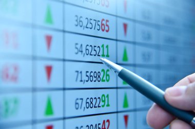 Ekranda gösterilen hisse senedi numaralarına işaret eden bir el. Çevrimiçi ticaret ve yatırım platformu kavramı. Kapat.