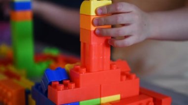 Little Child Builds Tower Of Colored Plastic Blocks. Concept Of Educational Games And Children Development. Close Up