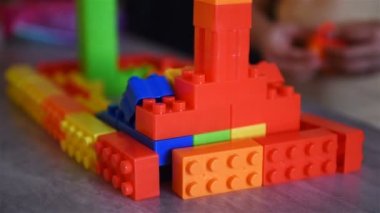 Hands Of Little Child Girl Playing With Colored Cubes On Table. Children Development And Educational Games Concept. Close Up