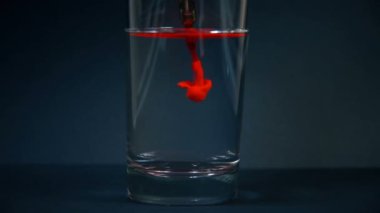 Kırmızı mürekkep iğnelerini camda temizleyen dövme makinesi. Sanat ve Tasarım Konsepti. Kapat.