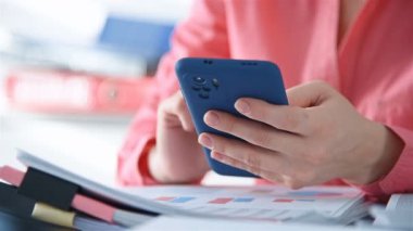 İş kadını cep telefonundan vergi verilerini hesaplıyor. Pazar Raporları ve Belgeler Konsepti