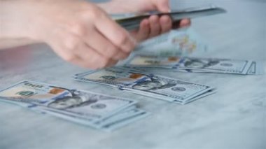 İş kadını Elleri Tahta Masa 'da Dolar Sayıyor. İş ve Finans Konsepti. Kapat.