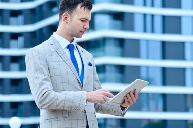 Genç tüccar hisse senedi verileri ile dijital tablet bilgisayar kullanıyor. İş ve bilgi teknolojisi kavramı. Kapat.