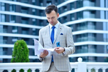 Trader man holding business stock data in hands. Finance, paperwork and business concept.