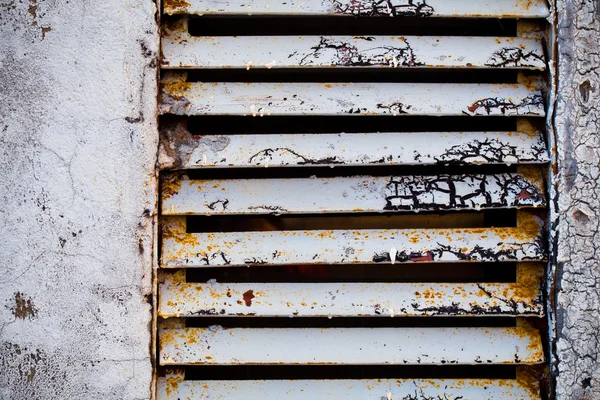 Rejilla de ventilación metálica antigua fijada en la pared gris . — Foto de Stock