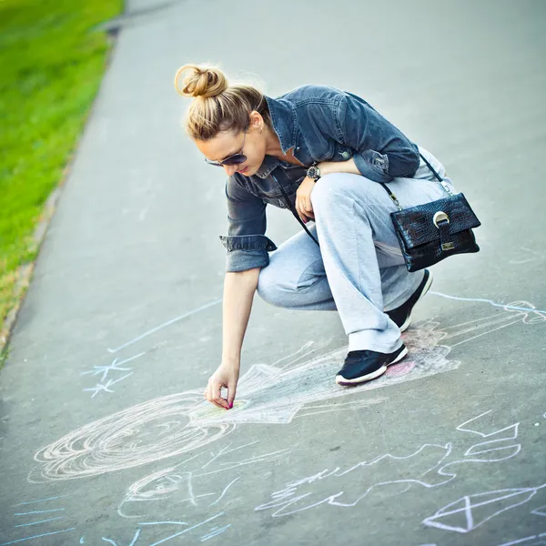 Das Mädchen zeichnet Kreide auf Asphalt — Stockfoto