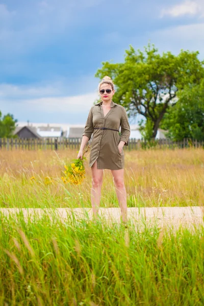 Bella ragazza con un mazzo giallo in mano. Campagna . — Foto Stock