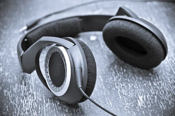 Headphones on a wooden table in vintage style. toning in blue color — Stock Photo, Image