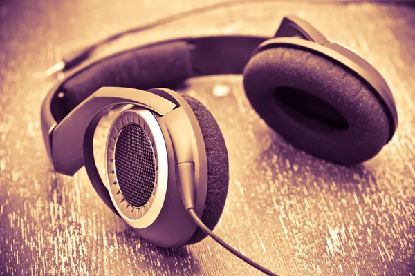 Auriculares en una mesa de madera de estilo vintage. foto tonificada . —  Fotos de Stock