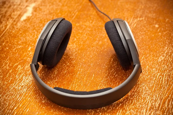 Headphones on old vintage board — Stock Photo, Image