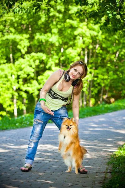 Onu köpek spitz ile gömlek ve pantolon açık havada güzel kız — Stok fotoğraf