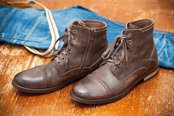 Kahverengi ve mavi kot pantolon deri ayakkabılar. şık deri çizmeler — Stok fotoğraf
