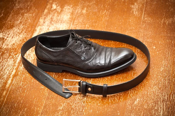 Klasszikus fekete bőr cipő és egy bőr öv a csat, a vintage háttér — Stock Fotó