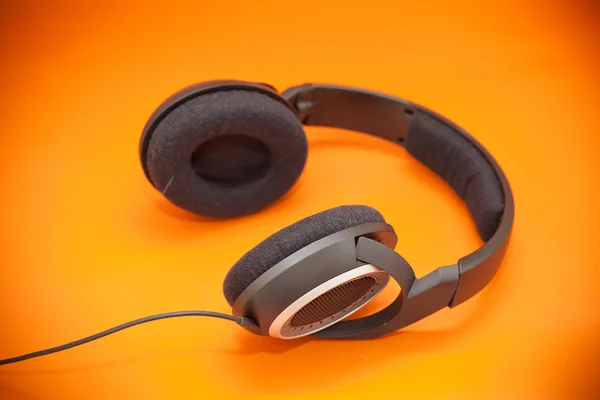 Kopfhörer auf orangenem Hintergrund — Stockfoto