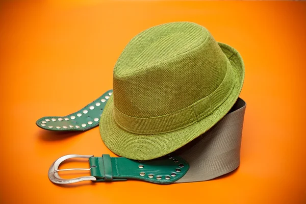 Chapéu verde e um cinto verde com uma fivela no estilo ocidental em um contexto cor-de-laranja — Fotografia de Stock