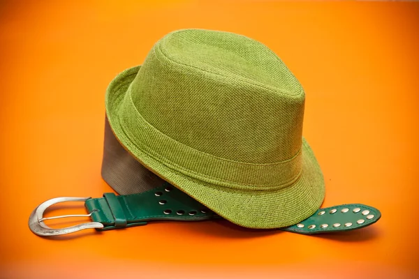 Cappello verde e cintura verde con fibbia in stile occidentale su sfondo arancione — Foto Stock