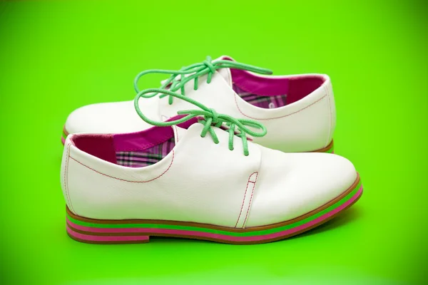 Chaussures blanches avec lacets verts sur fond vert — Photo