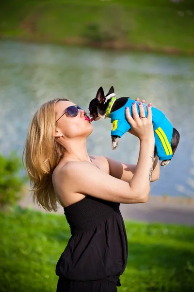 Belle jeune femme blonde avec chihuahua chien sur les mains à l'extérieur — Photo