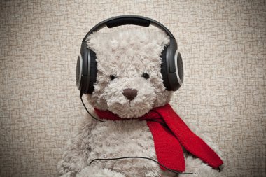 oyuncak oyuncak ayı ile kırmızı bir fular kulaklıklar müzik dinlemek