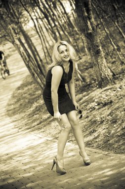 doğa gülümseyen güzel bir kızın portresi. seksi kız elbise ve ayakkabı orman. sepya tonlu fotoğraf