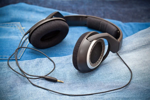 Headphones on a background of blue jeans — Stock Photo, Image