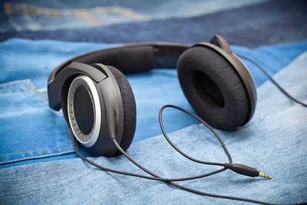 Headphones on a background of blue jeans — Stock Photo, Image