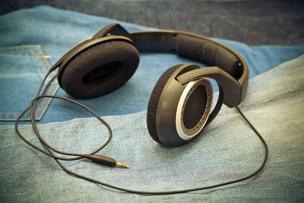 Headphones on a background of blue jeans — Stock Photo, Image
