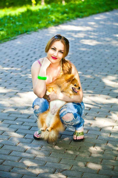 Dívka se psem v náručí venku — Stock fotografie