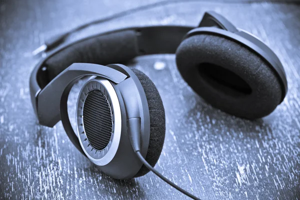 Auriculares en una mesa de madera de estilo vintage. tonificación en color azul — Foto de Stock