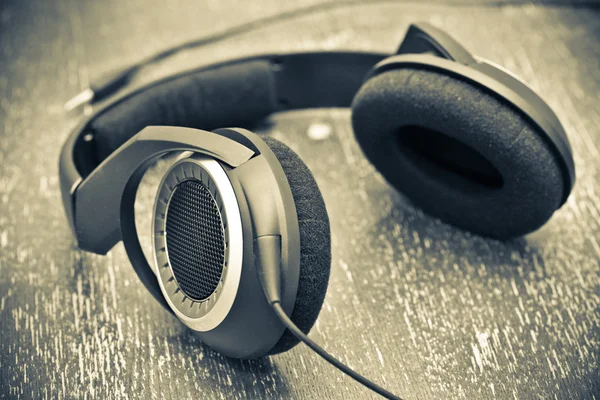 Headphones on a wooden table in vintage style — Stock Photo, Image