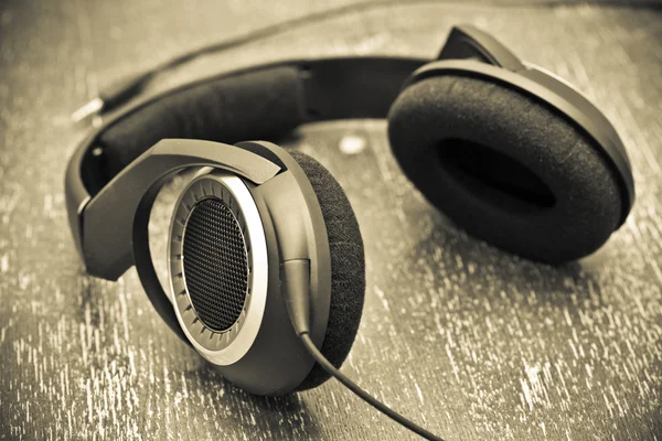 Headphones on a wooden table in vintage style — Stock Photo, Image