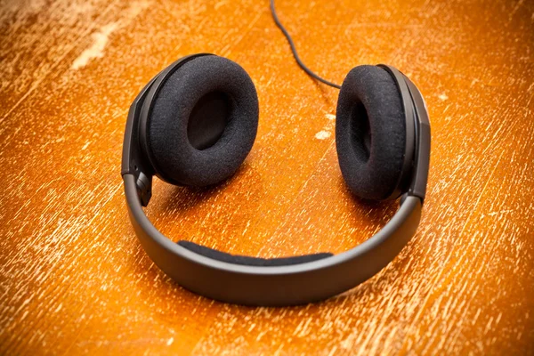 Headphones on old vintage board — Stock Photo, Image