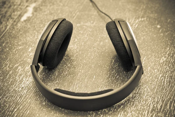 Headphones on a wooden table in vintage style — Stock Photo, Image