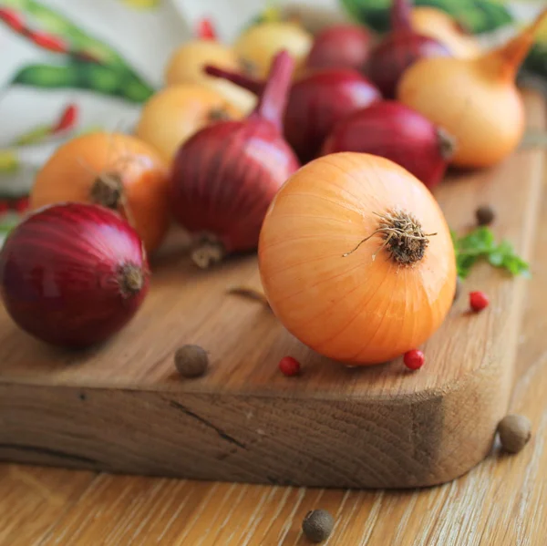 Röd och gul lök på skärbräda — Stockfoto