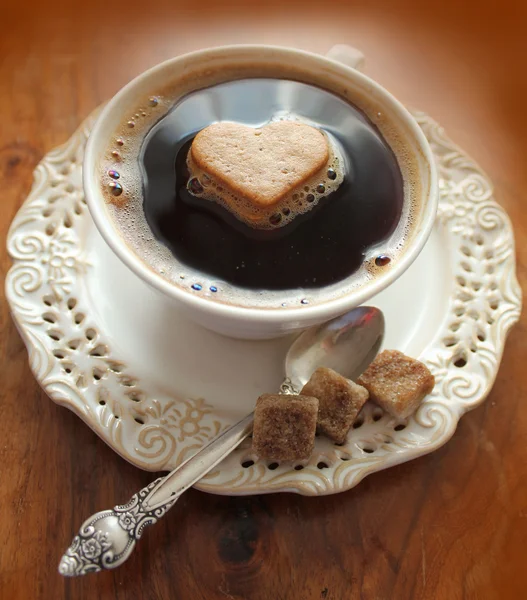 Filiżanka kawy z sercem na drewnianym stołem — Zdjęcie stockowe
