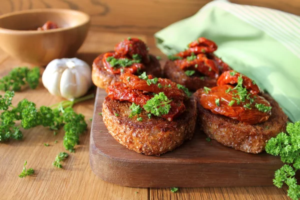 Aperitivo-bruschetta con aceite de oliva, tomates secados al sol y perejil —  Fotos de Stock